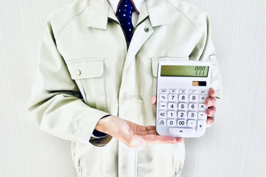 電卓を手にした男性の画像