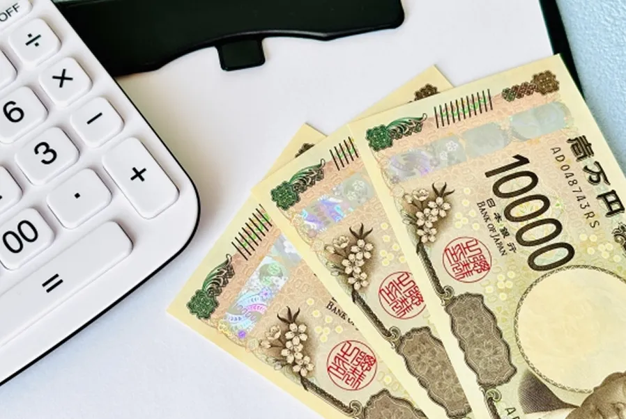 バインダーの上に電卓と現金が載った画像